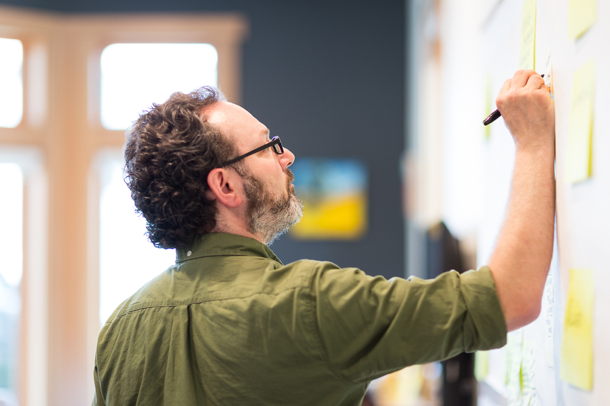 Scott Smith, a partner at Smith & Connors, facilitating a discovery session using a white board and sticky notes