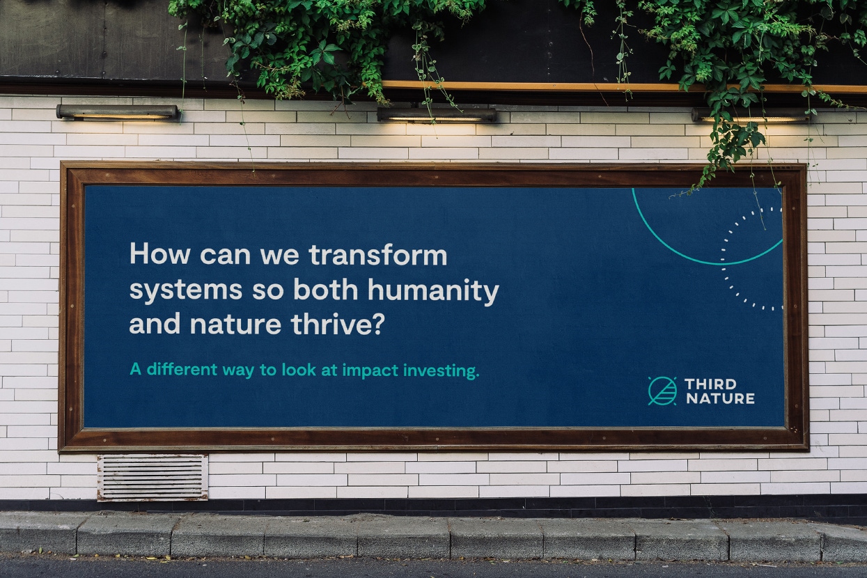 Photo of dark blue billboard with the text "How can we transform systems so both humanity and nature thrive?" The Third Nature logo appears in the corner.