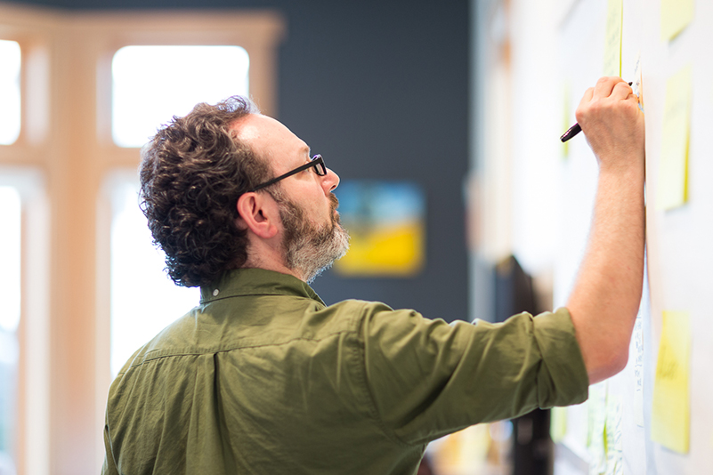 Scott Smith writing notes on a whiteboard