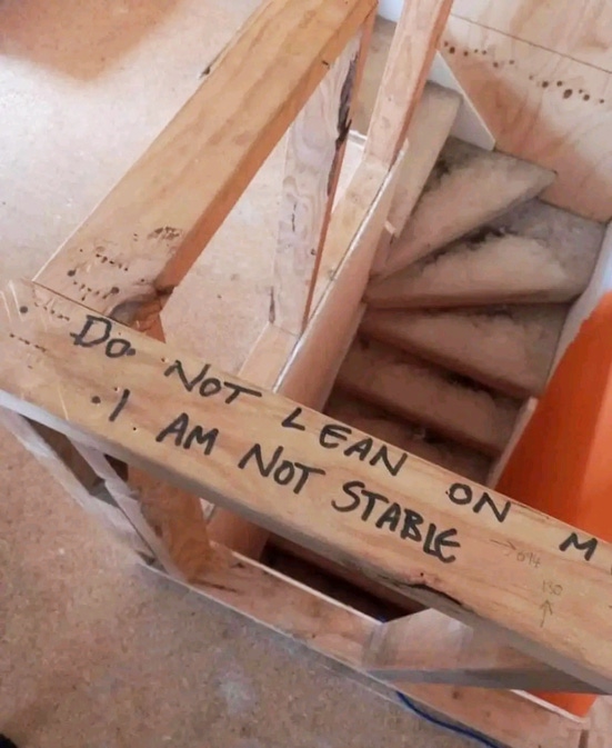 A spiral staircase under construction with the message Do not lean on me, I am not stable..