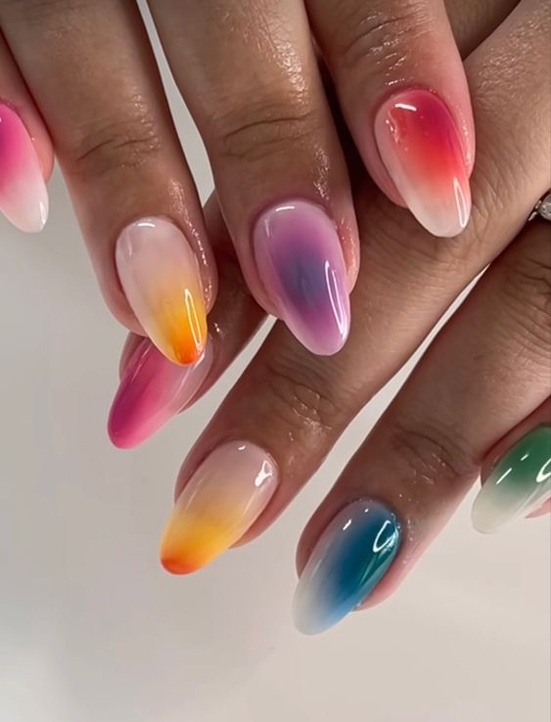 Colorfully painted fingernails with a gradient effect.