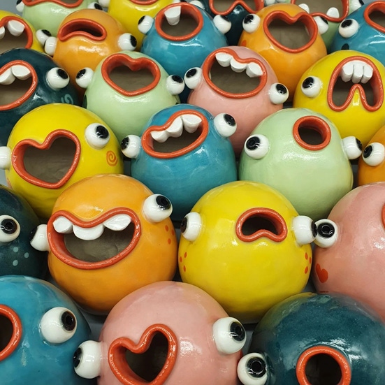 A colorful group of blob mugs with expressive faces.