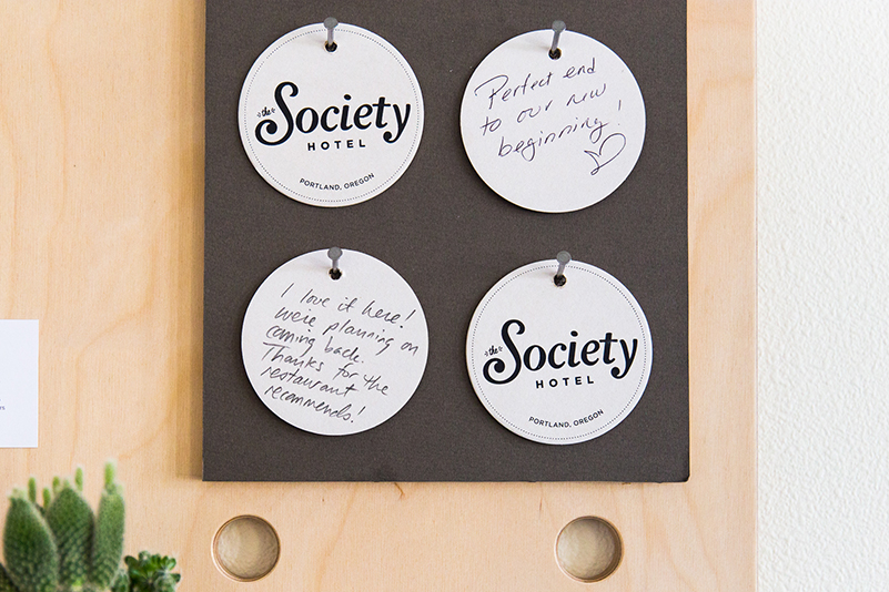 Society Hotel coasters hanging on a board. 