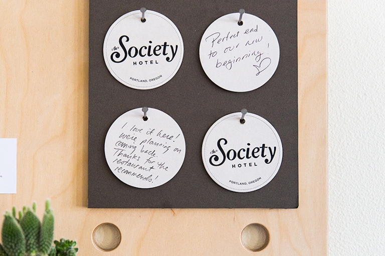 Society Hotel coasters hanging on a board. 