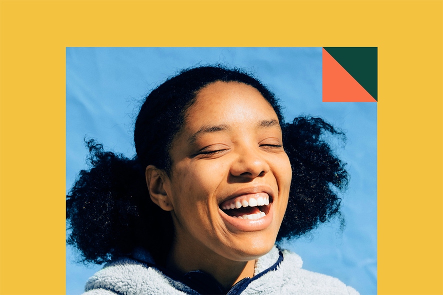 A Black woman smiling with eyes closed against blue backdrop, gold border and JOBL brand bug in corner.