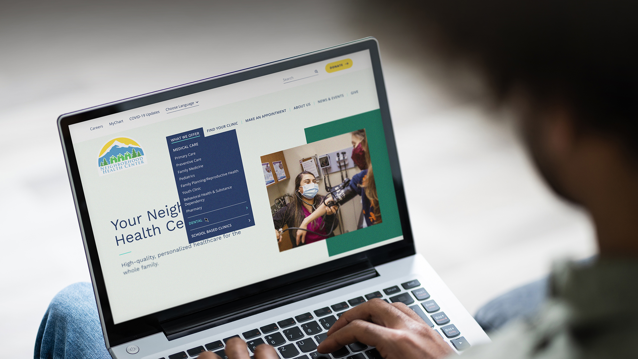 The Neighborhood Health Center website displayed on a laptop.