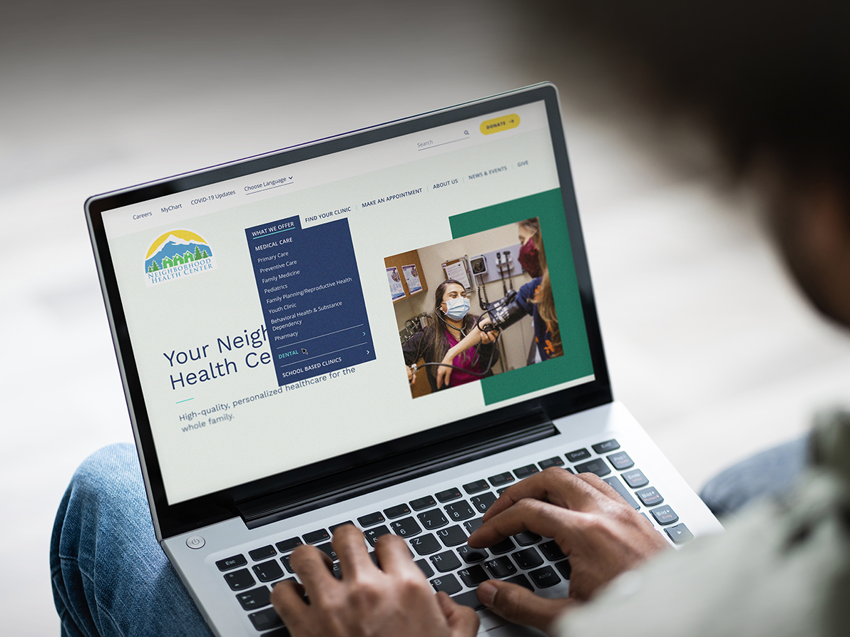 The Neighborhood Health Center website displayed on a laptop.