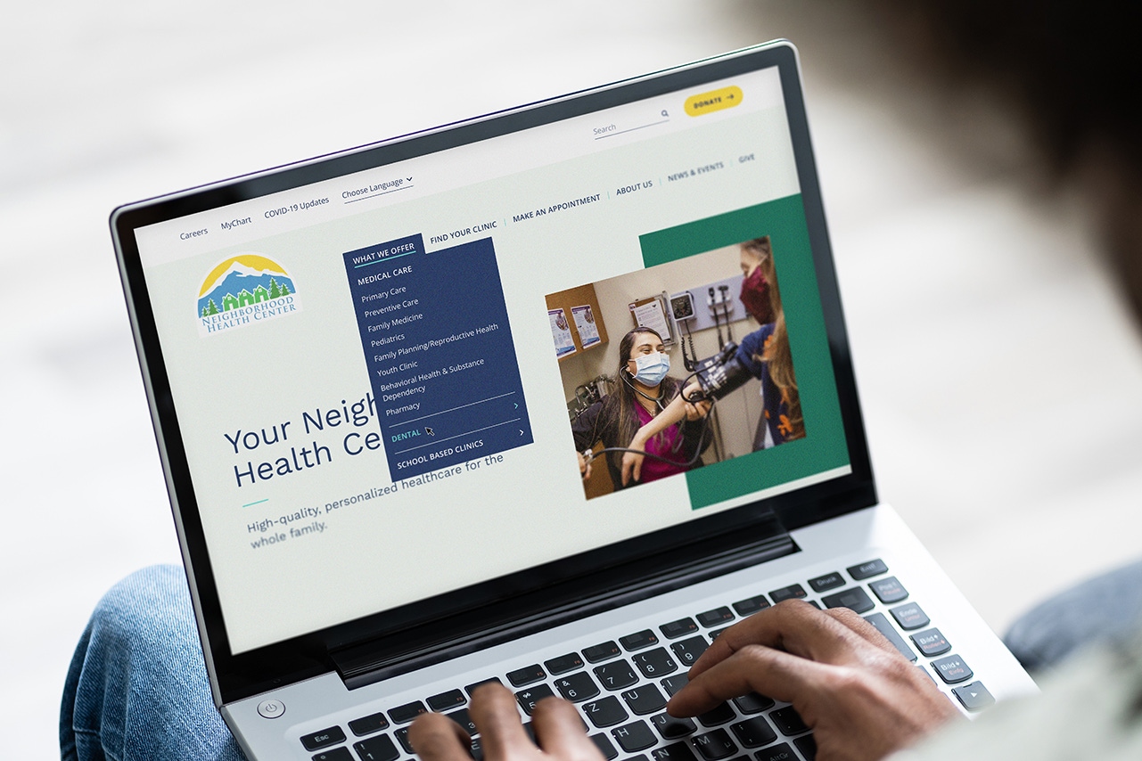 The Neighborhood Health Center website displayed on a laptop.