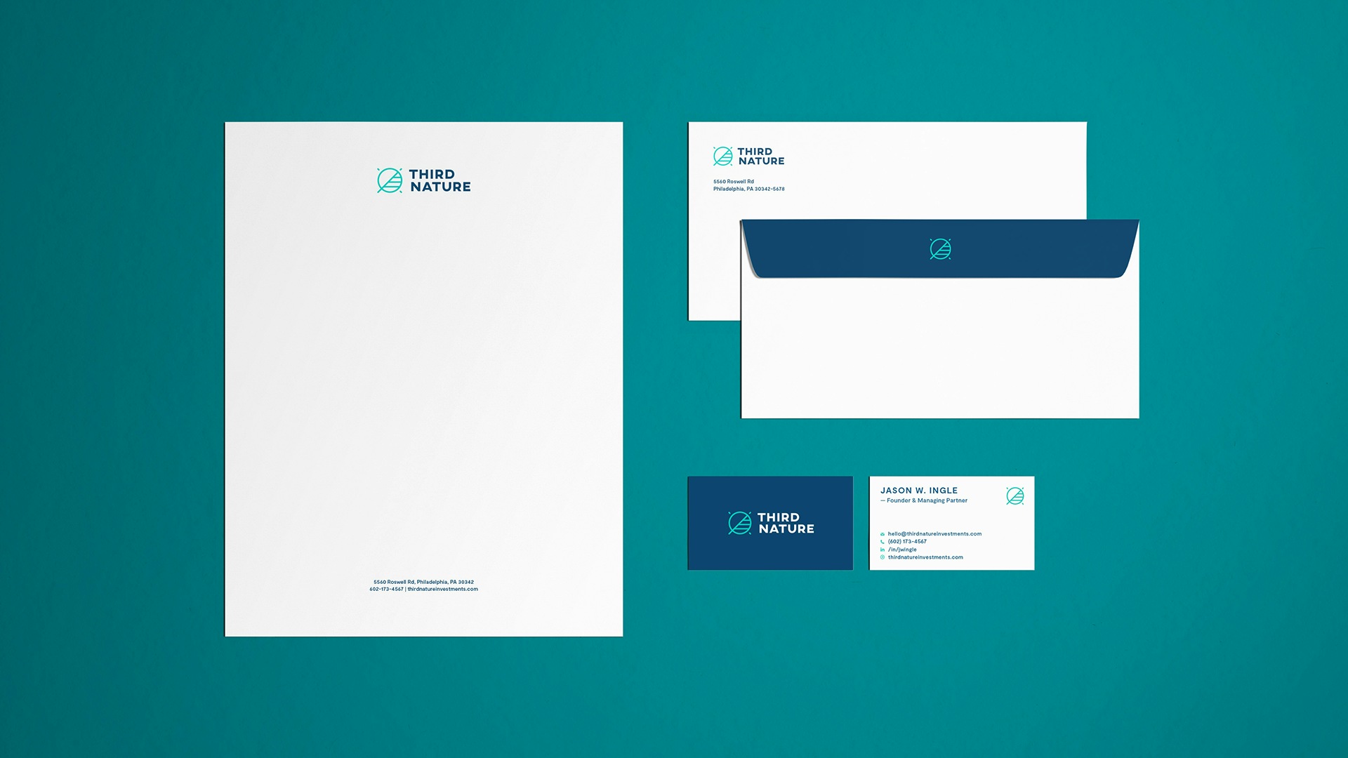 Third Nature stationery laid out in an orderly manner over a teal backdrop. It includes note paper, an envelope's front and back, and the front and back of Jason Ingle's business card.