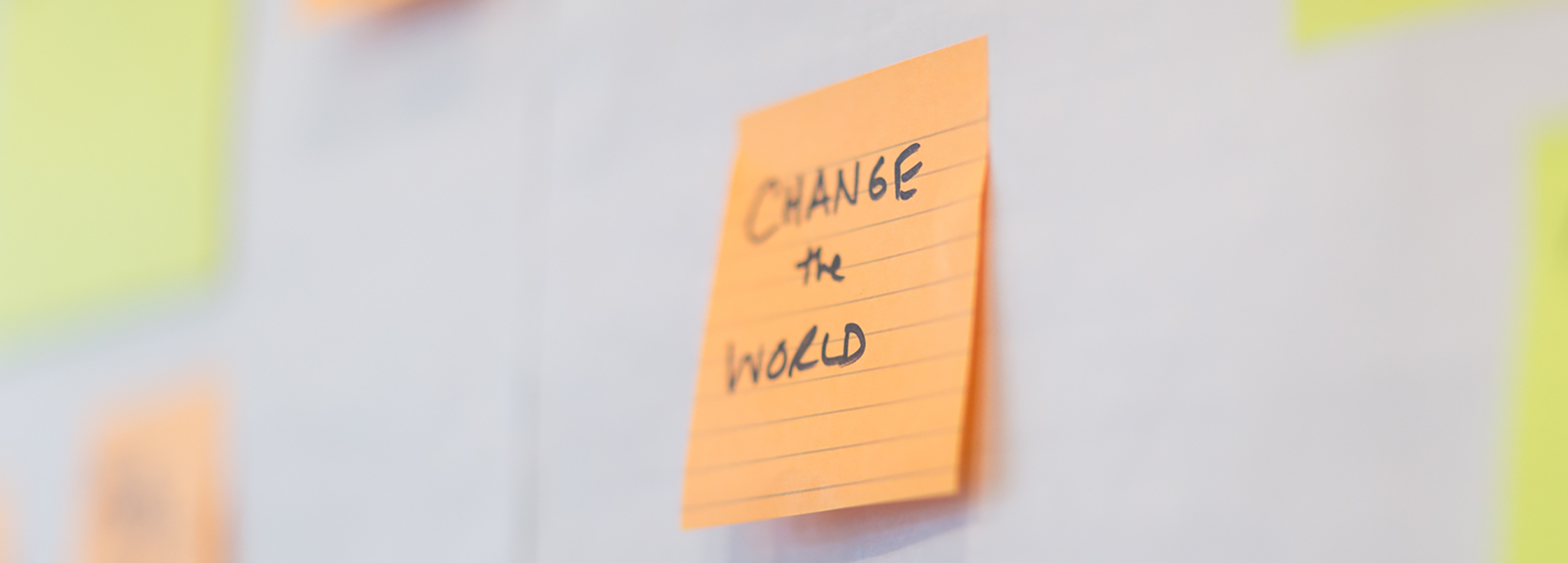 Post it note with the words change the world. 