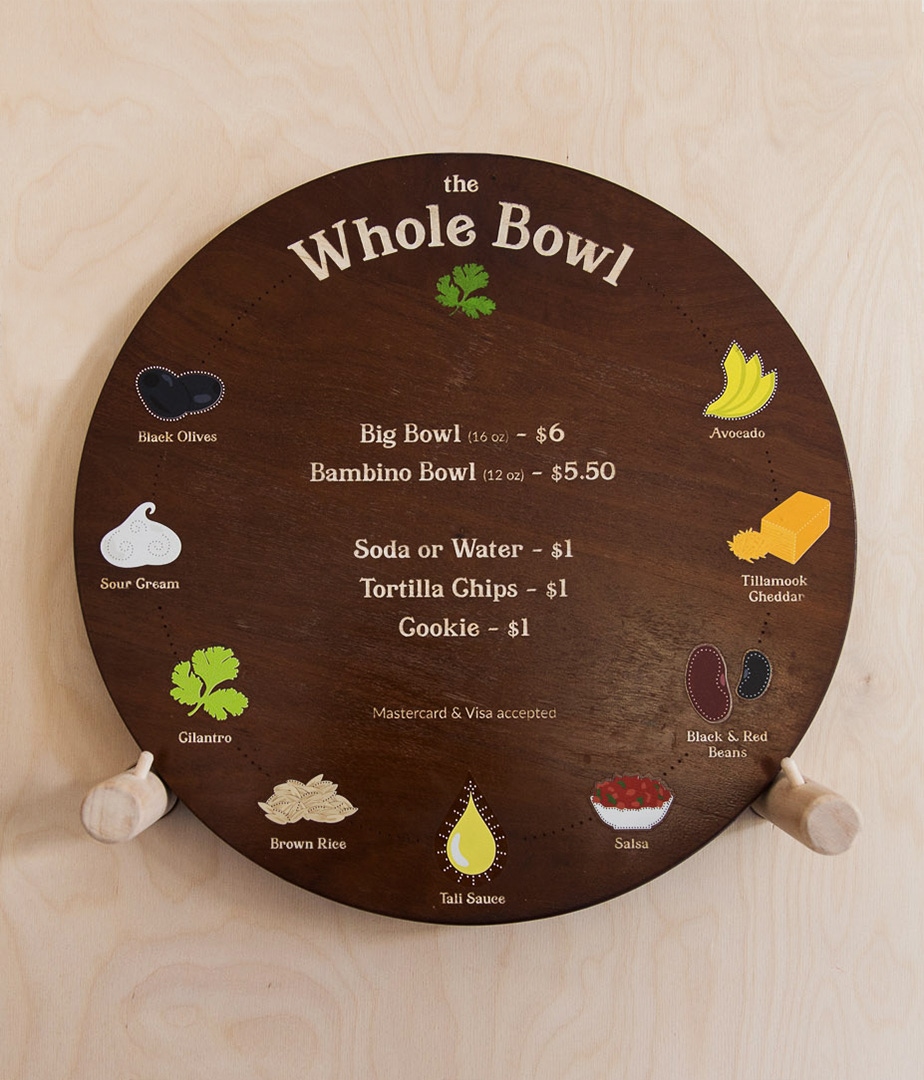 The Whole Bowl menu is a round wood base with decals for each of the bowl ingredients around the circumference.