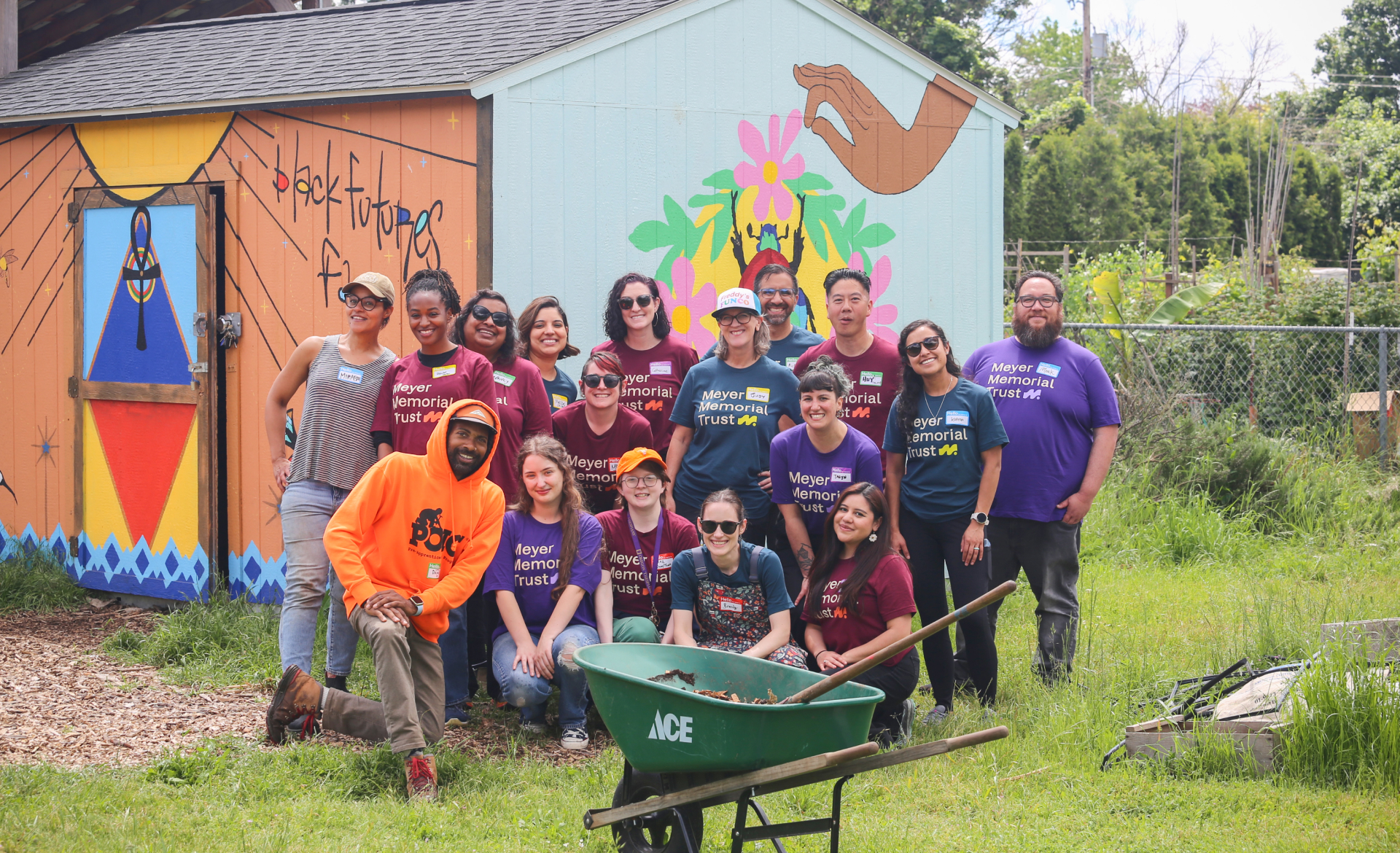 Group of Meyer Memorial Trust staff and partners smiling in front of a colorful mural that reads “Black Futures.”